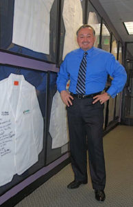 Brian with autographed smocks from some top doctor clients that he inspires and motivates