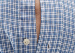 Man will a belly bulging out of his button up shirt.